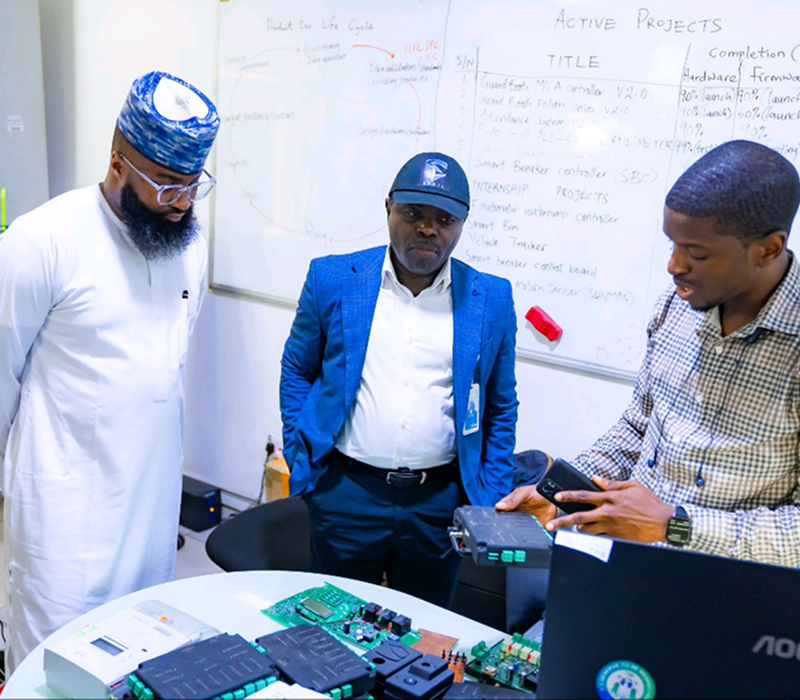 Team reviewing circuit board in meeting room
